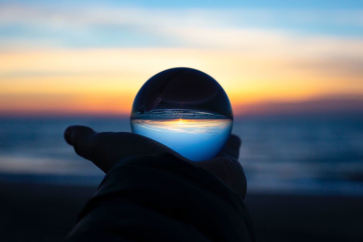 Image of a clear orb reflecting the sunset.